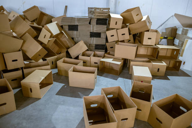 istock Assembled and disassembled folding cardboard boxes of perforated sheets of corrugated cardboard. Packaging of finished products in industrial production. 1369835102