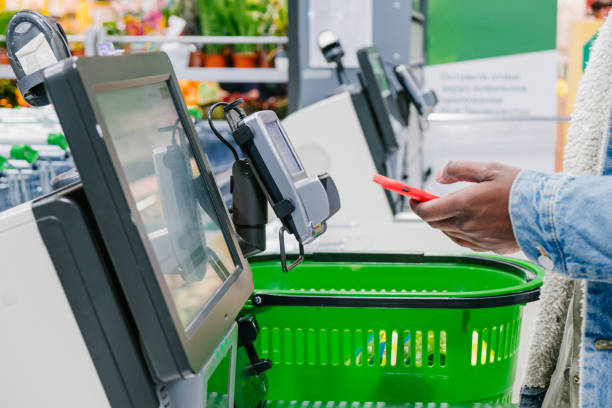 istock Black guy uses smartphone to pay at self-checkout point 1369835156