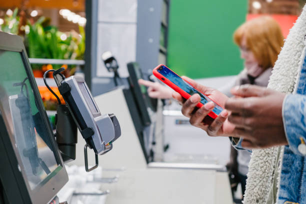 istock Black guy uses smartphone to pay at self-checkout point 1369835176