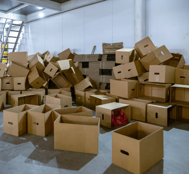 istock Assembled and disassembled folding cardboard boxes of perforated sheets of corrugated cardboard. Packaging of finished products in industrial production. 1369835989