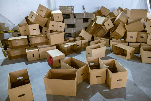 istock Assembled and disassembled folding cardboard boxes of perforated sheets of corrugated cardboard. Packaging of finished products in industrial production. 1369835990