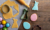 Easter greeting card with cooking homemade gingerbread cookies and colorful eggs.