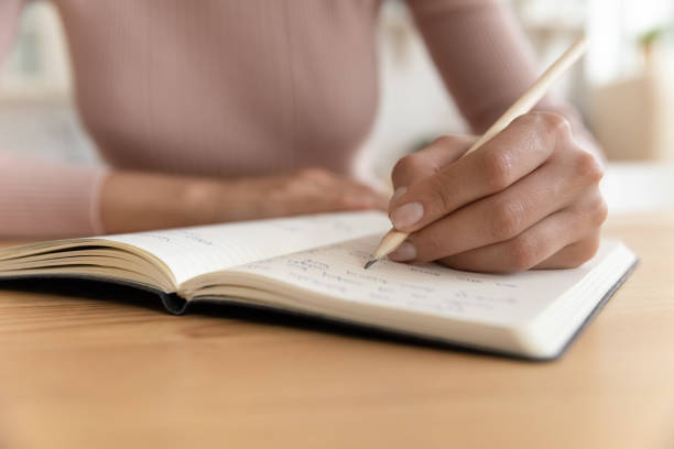 istock Close up of woman handwrite in notebook 1369837660