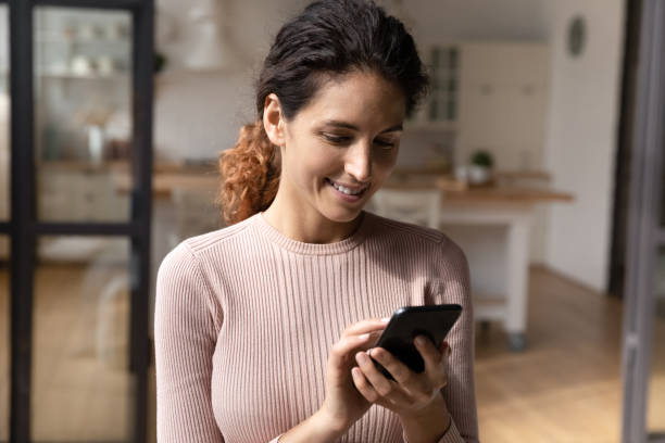 istock Smiling woman use smartphone texting online on gadget 1369837943