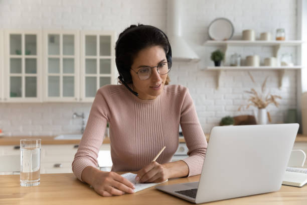 istock Young woman in headphones study online on computer 1369838683