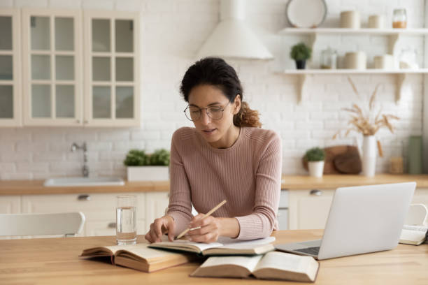 istock Millennial female study online with textbooks at home 1369838687