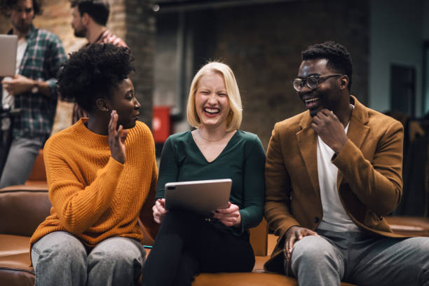 istock Colleagues laughing and brainstorming at modern office. Start up ptoject. 1369840006
