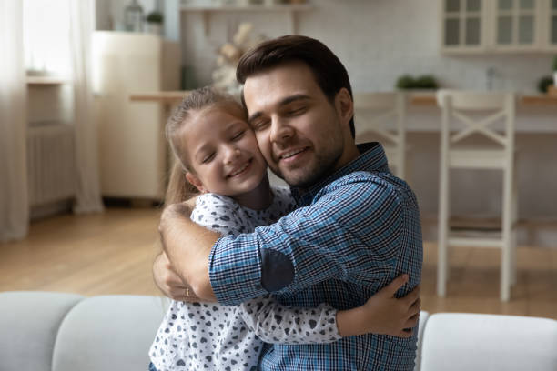 istock Affectionate happy young father cuddling little daughter. 1369841333
