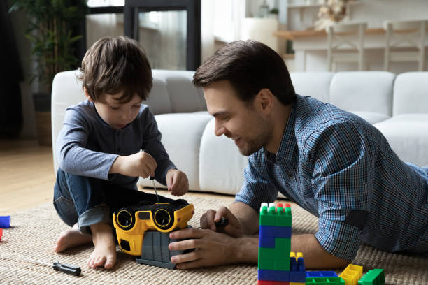 istock Concentrated small boy fixing car with caring dad. 1369841341