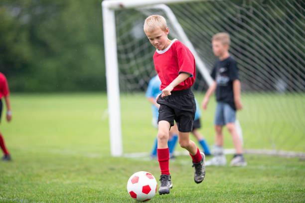 istock Young Boy Kicking a Soccer Ball 1369844131