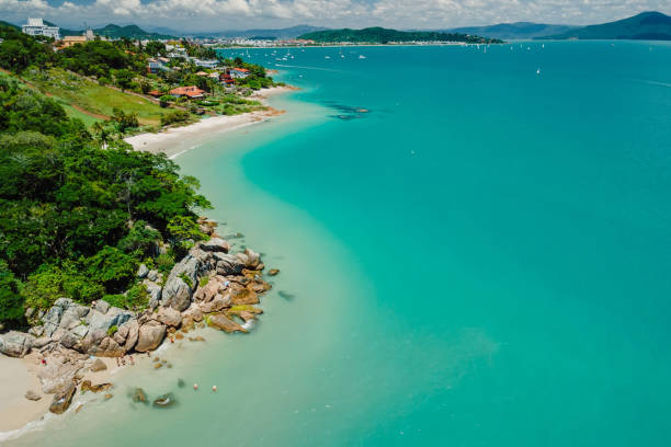 Tropical holiday beach with rocks and turquoise ocean. Aerial view Tropical holiday beach with rocks and turquoise ocean. Aerial view florianópolis stock pictures, royalty-free photos & images