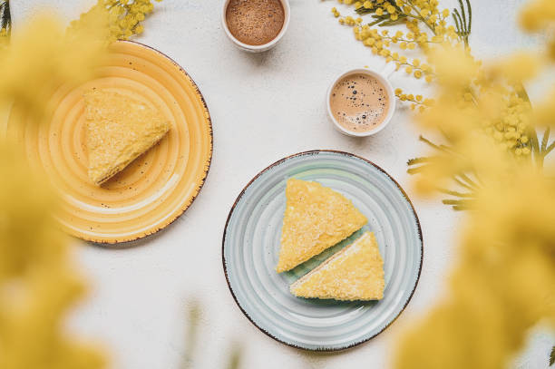 istock yellow mimosa cake. Easter breakfast flat lay. Cakes, cup of coffee 1369846833