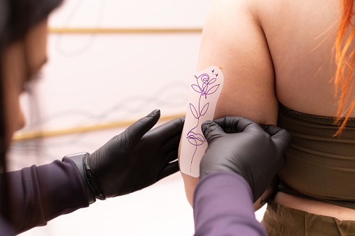 Artista del tatuaje trabajando en calcomanías de tatuajes photo