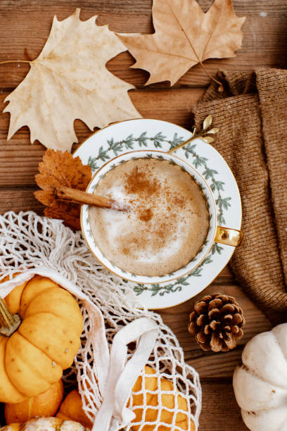 Cup of Pumpkin Spice Latte and Fall Decor from fresh  pumpkins. Traditional Coffee Drink for Autumn Holidays, cozy, hygge, comfortable stock photo
