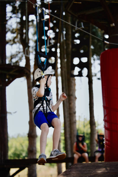 istock Happy little boy enjoying ropes course adventure park 1369848415