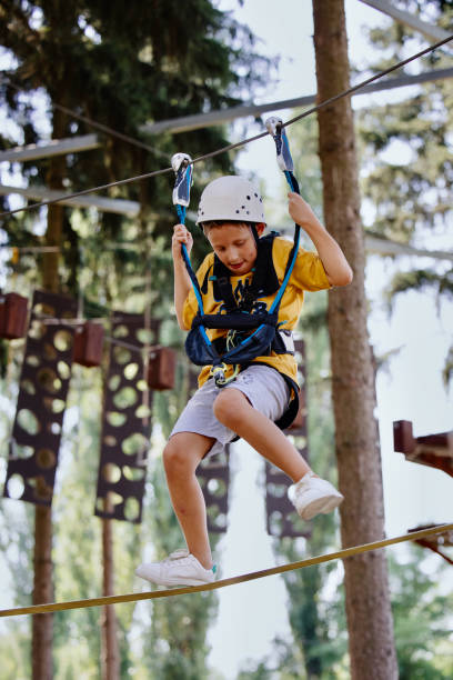 istock Little boy practicing in ropes course in adventure park. 1369848543