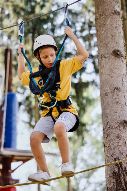istock Little boy practicing in ropes course in adventure park. 1369848559