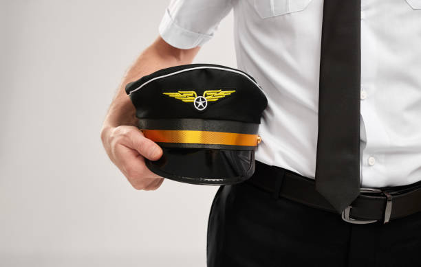 istock Crop airline captain with peaked cap in studio 1369850478