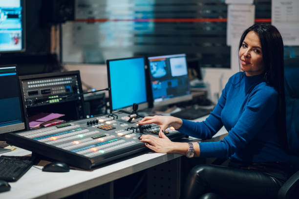 Middle aged woman using equipment in control room on a tv station