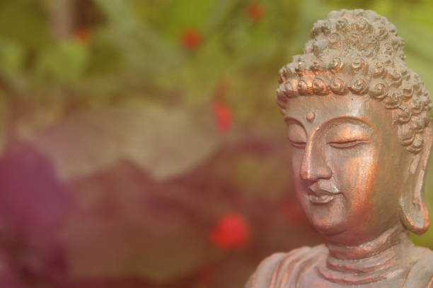 istock Buddha Statue in Garden with blurred flowers in background 1369853449