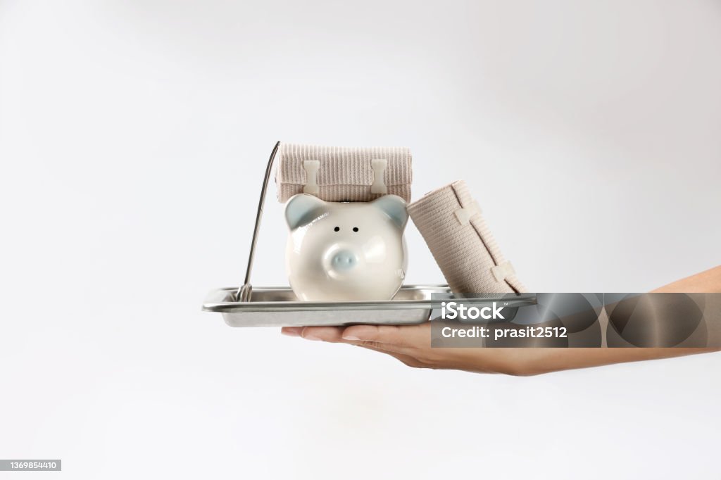 Hand with first aid supplies. Piggy bank. Money saving concept. Health insurance and family accident protection Bandage Stock Photo