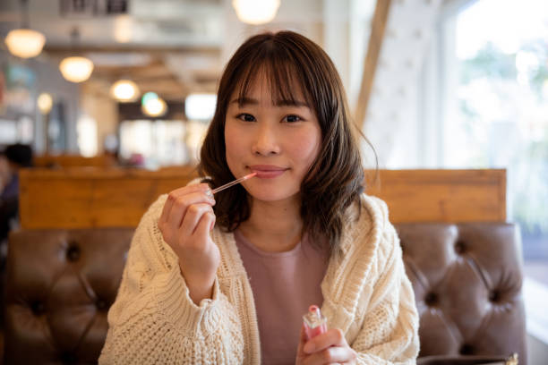 istock Woman applying lipstick after lunch in cafe 1369855504