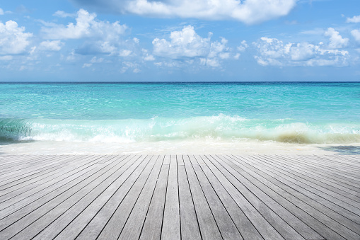 Empty wooden platform and tropical turquoise sea with blue sky background