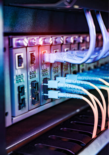 istock Fiber Optical cables connected to an optic ports and Network cables connected to ethernet ports 1369864678