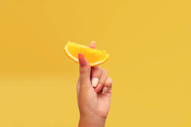 istock Women's hand shows one piece of orange 1369872634