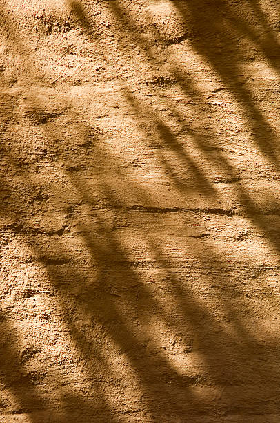 golden plastered pared de ladrillo viejo con sombras - foto de stock