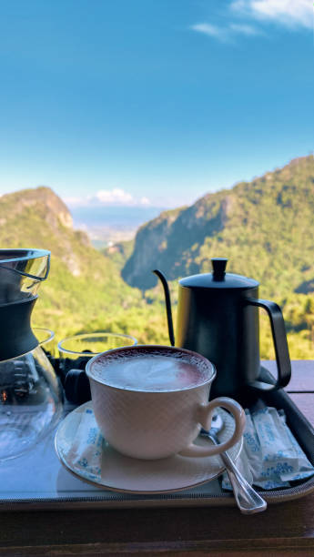 istock Vertical a close-up shot, Equipment for making drip coffee beautiful mountain view cool morning. Hot Latte in the white cup. 1369875969