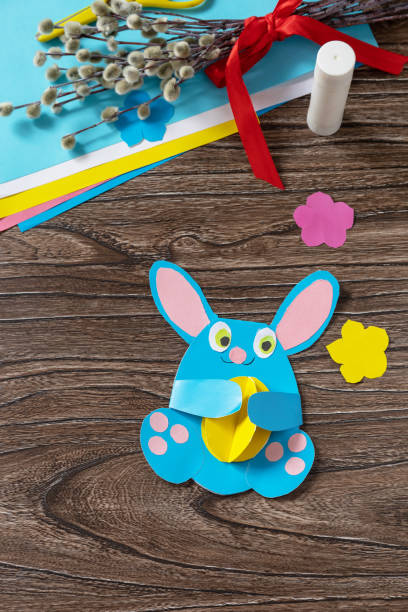 istock Congratulation Easter bunny toy card with easter egg. Handmade. Project of childrens creativity, handicrafts, crafts for kids. 1369882559
