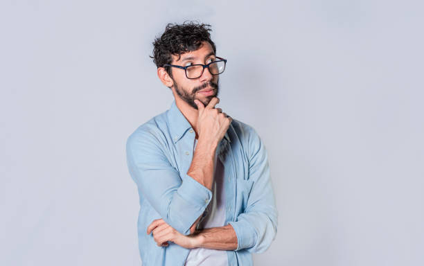 istock young man wondering with his hand on his chin on an isolated background, a guy thinking with his hand on his chin. 1369887954