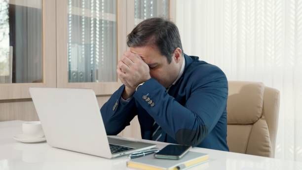 istock Stressed businessman feeling sick and tired while sitting at his working place 1369891539
