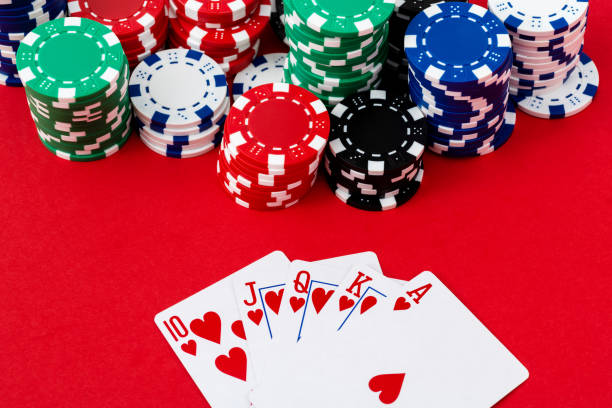 istock Gambling chips and royal flush on red background 1369892727