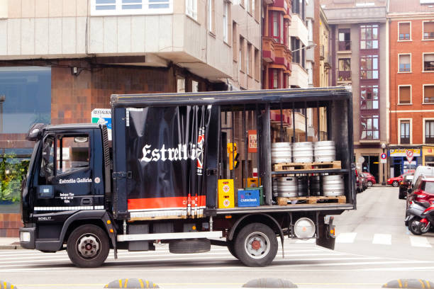 Beverages delivery truck. Gijón, Spain - june 9, 2021: Beer, water and soda delivery truck, curtain partially folded, and  crates and bottles. City street in Gijón , Asturias, Spain. beer crate stock pictures, royalty-free photos & images