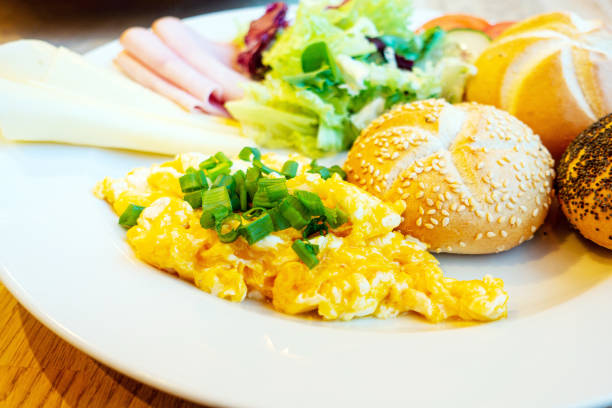 istock Healthy breakfast prepared with three little breads, scrambled eggs, ham, cheese and fresh lettuce for a full meal. 1369894224