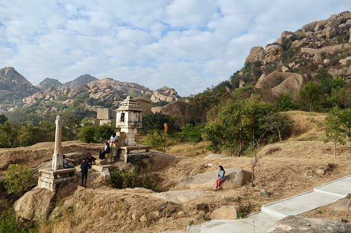 Chitradurga, Karnataka, India - 30 Jan 2022: A group of tourists enjoying the view at the Nandi Temple(Also called Onti Kalu Basava Temple) at Chitradurga Fort. The fort is also called Elusuttina Kote (meaning the fort of seven circles).