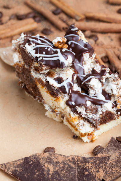 a multi-layered cake made of chocolate and cream cakes in a chaotic order in the cake, lot of chocolate, cinnamon and cocoa powder scattered around the cake