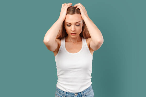 istock Young beautiful woman has headache isolated on color background 1369899078