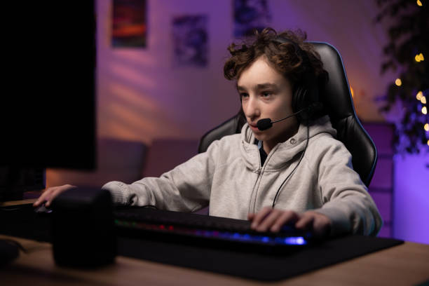 istock School-age boy pro gamer spends time playing computer games, focused child has headset to talk to team, room lit with neon, led lights, gaming accessories 1369899103