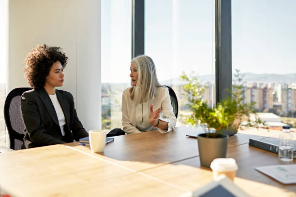 donne d'affari che discutono idee nell'ufficio aziendale - ceo serious board room manager foto e immagini stock