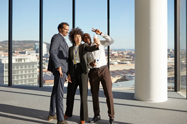 istock Diverse corporate colleagues taking selfie in sunny office 1369899304