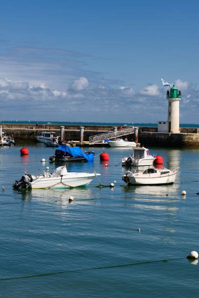 View on Phare de la Flotte View on the Phare de la Flotte and some boats on the sea from the beach plage de l' Arnérault on a sunny summerday flotte stock pictures, royalty-free photos & images