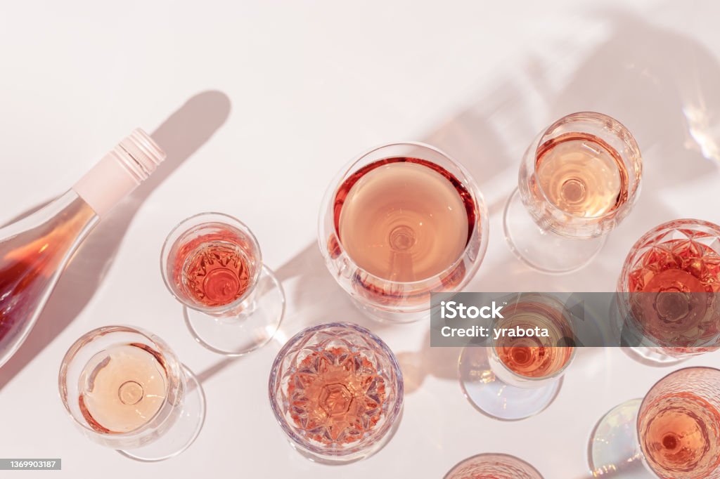 ローズワインとボトルスパークリングピンクワインのトップビューの多くのグラス。パーティーのための軽いアルコール飲料。 - ロゼワインのロイヤリティフリーストックフォト