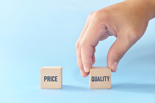 Concepto de calidad sobre equilibrio de precios. Elegir a mano el cubo de bloque de madera con palabra calidad versus precio. photo