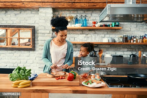 istock African American mother and daughter preparing a meal in the kitchen. 1369908230