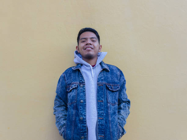 istock friendly mexican young man standing isolated on unicolor wall 1369910370