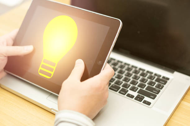 istock hand hold tablet with light bulb idea illumination in business technology 1369912757