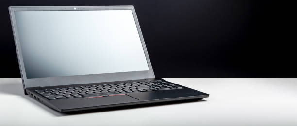 istock Empty open laptop with mockup on white desk table with black screen. minimalist work space with modern notebook. Laptop screen template for website digital design. Long web banner with copy space 1369912939